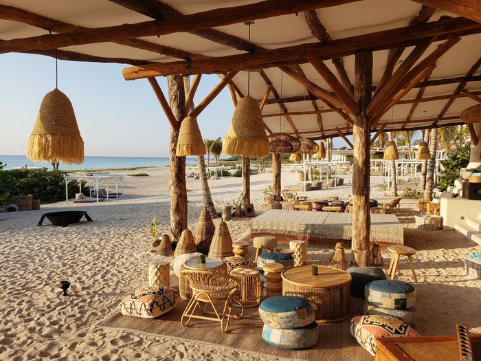 Beach club de Palmaïa con palapas sobre la arena