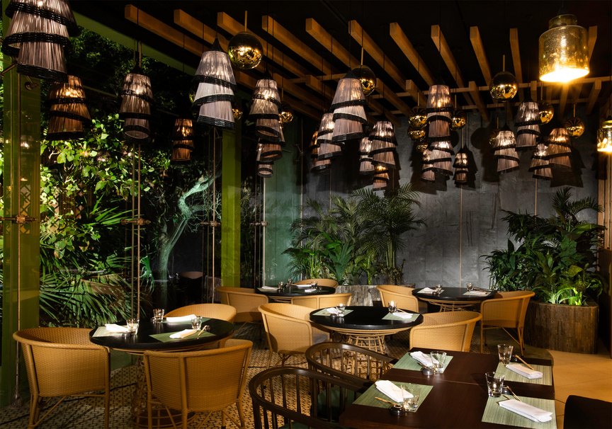 Restaurante del resort Palmaïa con vegetación y luz cálida